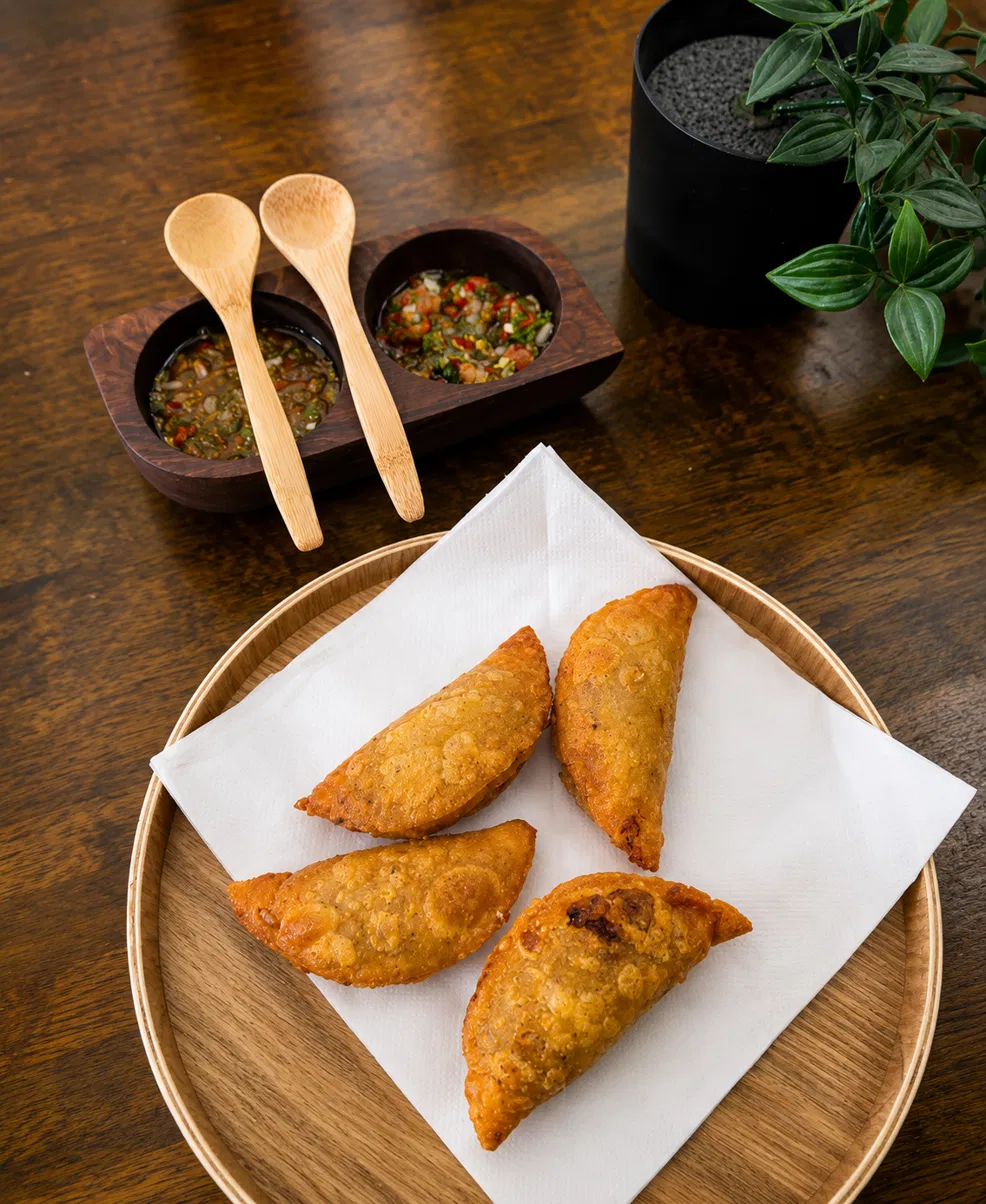 Colombian empanadas served with two ají dipping sauces